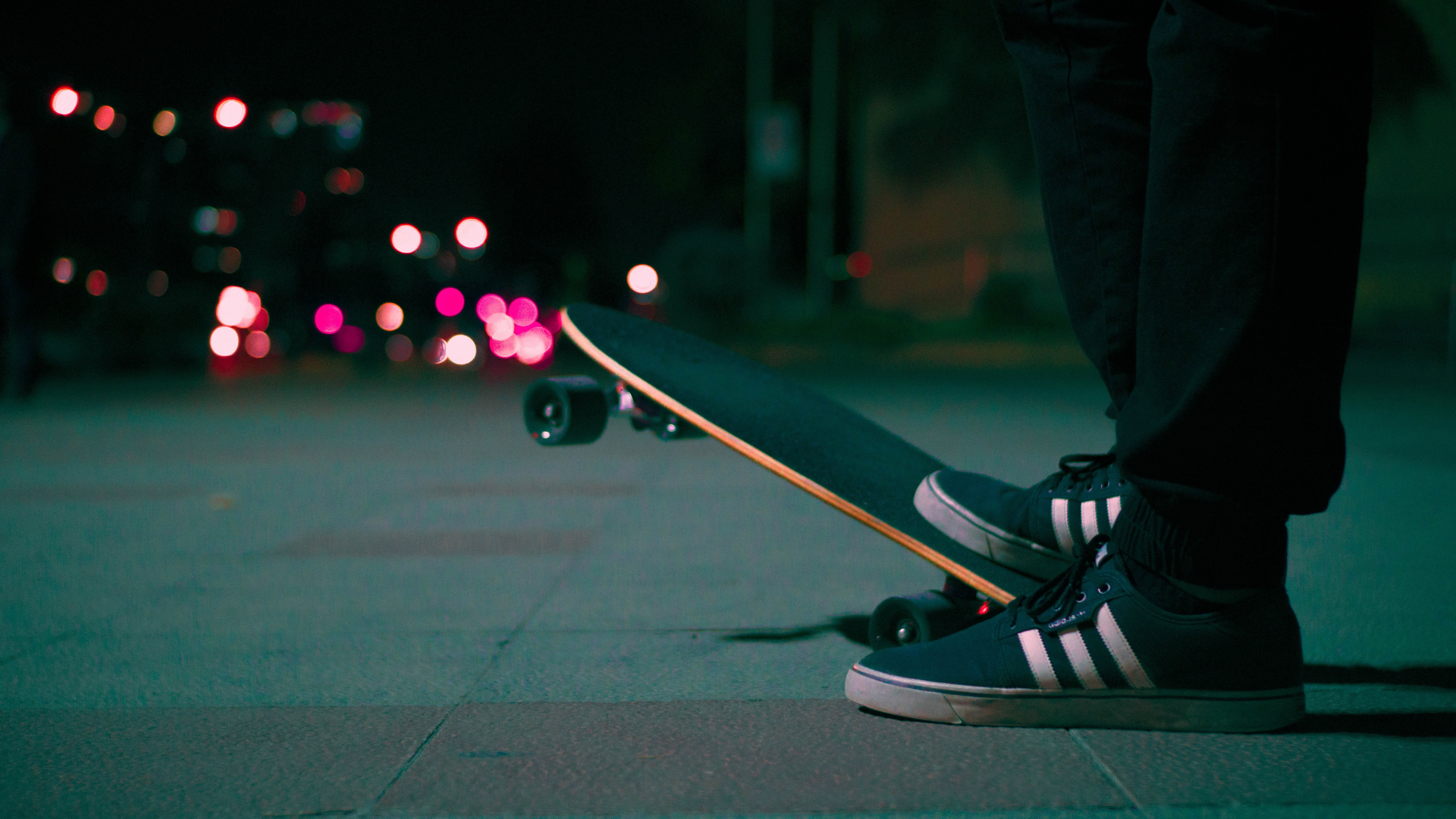 Guy holding his board on a hill